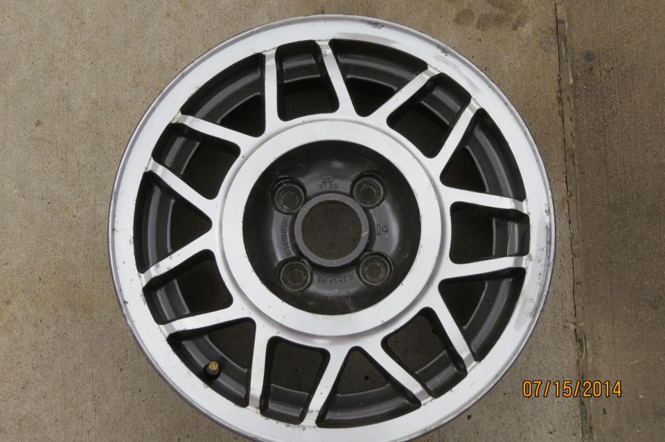 Silver alloy wheel with black spokes and a four-lug bolt pattern