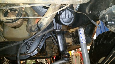 1988 Ford Bronco - Underside view of vehicle steering and suspension components, including a shock absorber.