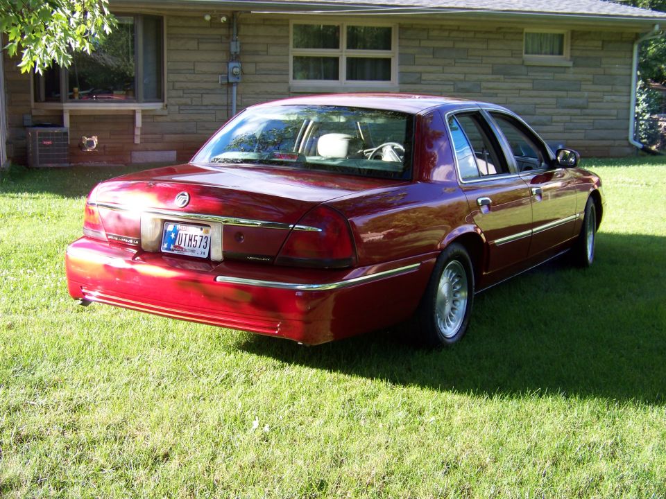 Red 1999 Mercury Grand Marquis, rear view, parked on grass