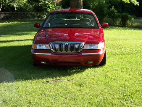 1999 Mercury Grand Marquis - Red 1999 Mercury Grand Marquis parked on a grassy lawn.