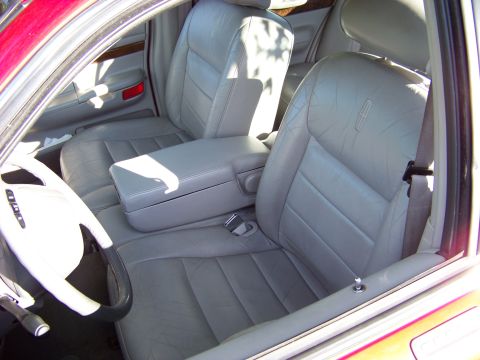 1999 Mercury Grand Marquis - The interior of a car features light gray leather seats and a prominent center console.