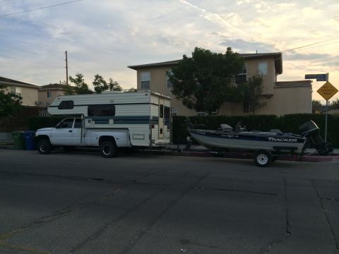 1997 Dodge 3500 - A white 1997 Dodge 3500 pickup truck is parked on the street, towing a boat on a trailer.