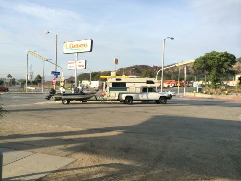 1997 Dodge 3500 - A 1997 Dodge 3500 pickup truck with a camper shell is seen towing a boat trailer.