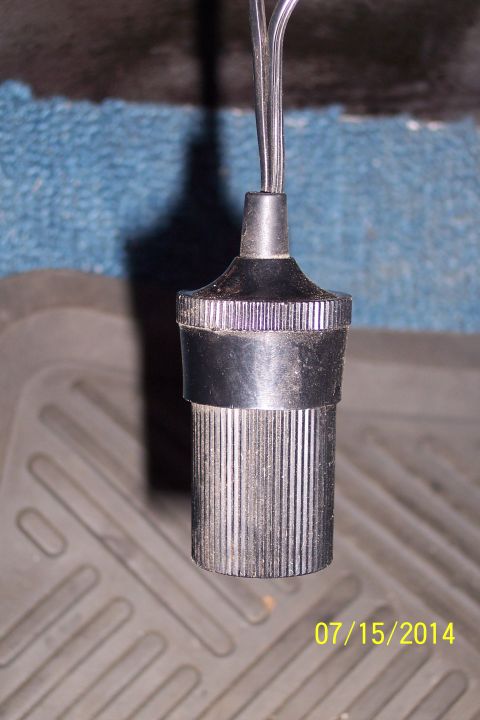 1990 Ford Bronco - A close-up view of a vehicle's cigarette lighter socket, showing the metal receptacle and attached wires.