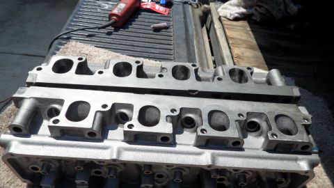 1972 Ford Ranchero - Engine cylinder heads are shown on a truck bed, with a rotary tool nearby.