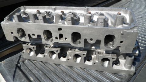1972 Ford Ranchero - A pair of aluminum engine cylinder heads are shown resting on a truck bed's surface.