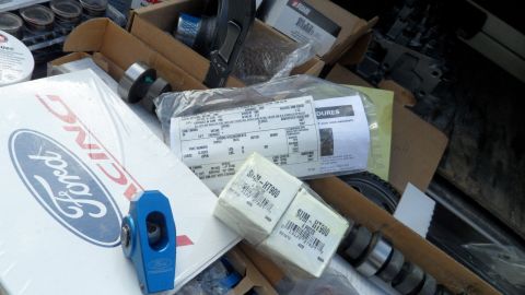 1972 Ford Ranchero - Pile of assorted automotive parts, including a Ford Racing box and a blue rocker arm.