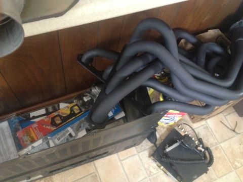 1979 Ford Bronco - Black exhaust headers are visible in a box with other automotive parts.