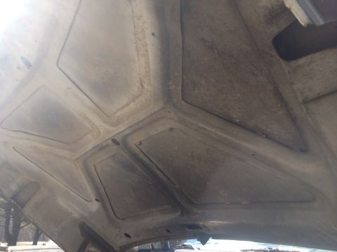 1979 Ford Bronco - The underside of a vehicle's hood shows a dusty, reinforced structure.