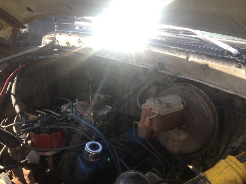 1979 Ford Bronco - The engine bay of a 1979 Ford Bronco shows a V8 engine with a carburetor and brake booster.
