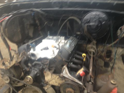 Engine bay with engine components visible, including valve covers and intake manifold
