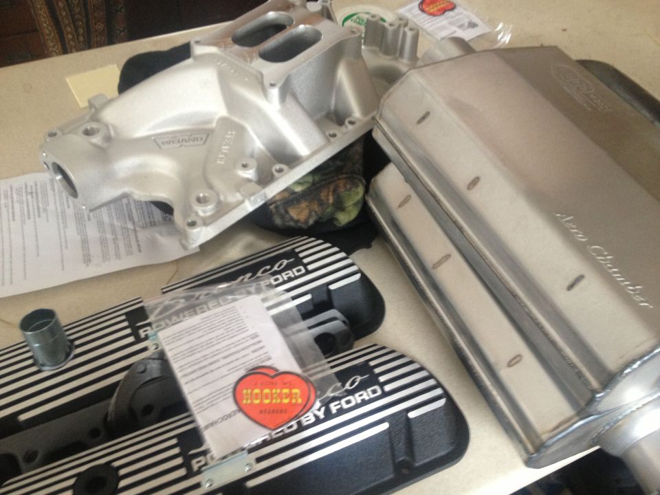 Aluminum intake manifold, two valve covers reading "POWERED BY FORD", and a Hooker header sticker