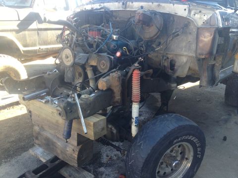 1979 Ford Bronco engine bay with engine removed, supported by wooden blocks