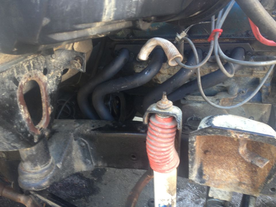 Engine bay with exhaust headers and red shock absorber boot