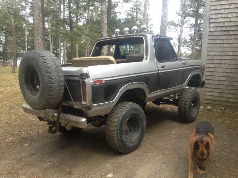 Rear view of a lifted 1979 Ford Bronco with a spare tire mounted externally