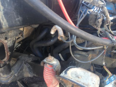 Close-up of engine bay showing exhaust manifold and wiring