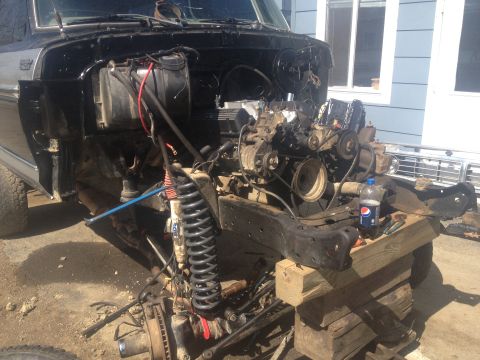 Front end of a 1979 Ford Bronco chassis with engine removed, showing suspension and frame