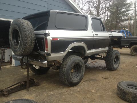 1979 Ford Bronco, rear 3/4 view, lifted, two-tone silver and black with spare tire