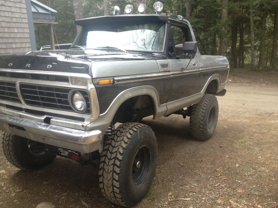 Two-tone black and silver Ford Bronco with off-road tires and roof-mounted lights
