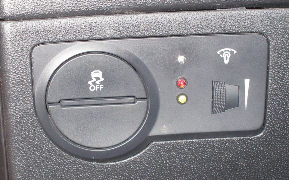 Close-up of ESC OFF button and indicator lights on a car's dashboard