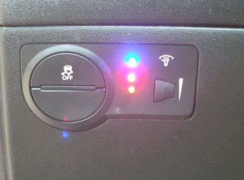 2010 Hyundai Genesis - Close-up of dashboard controls, including a button to turn off traction control and several illuminated indicator lights.