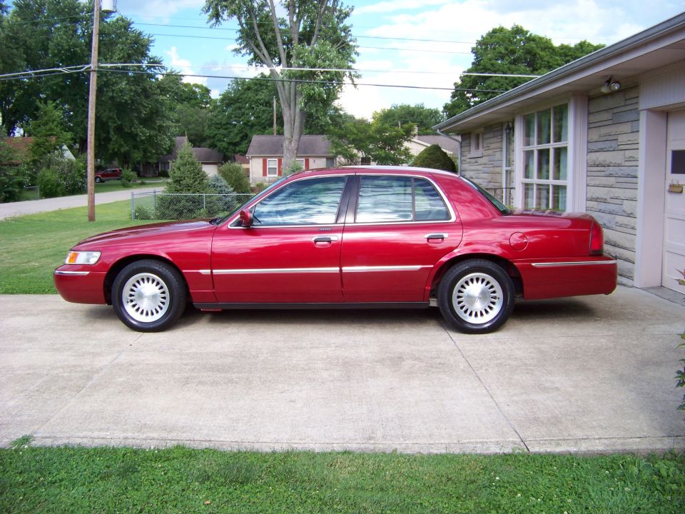 Red 1999 Mercury Grand Marquis sedan, side view