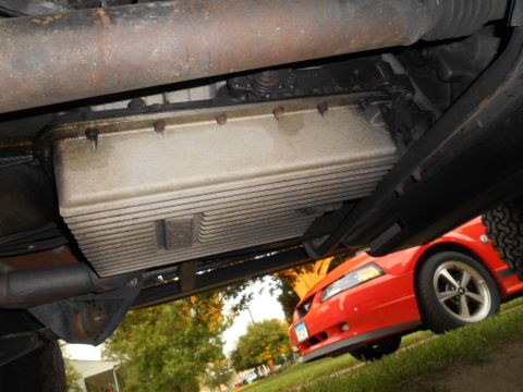 1994 Ford Bronco - Underside view of a vehicle with a red 2000s Ford Mustang visible in the background.