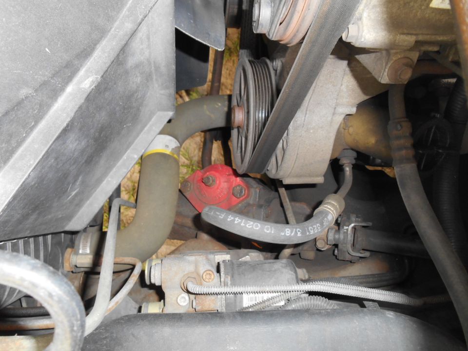 Close-up of engine bay showing hoses, belts, and pulleys