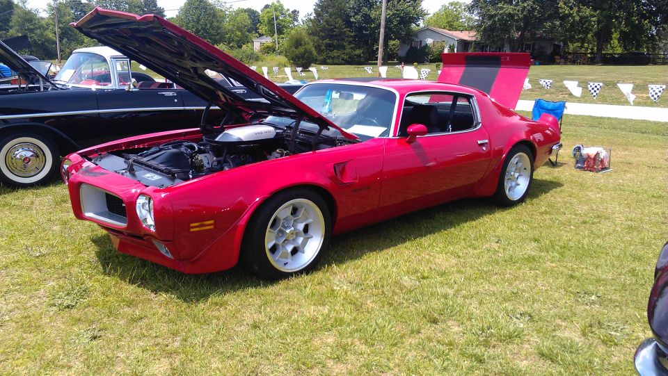 Red 1972 Pontiac Trans Am with hood and trunk open, showing engine and rear spoiler