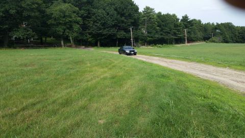 1991 Ford LTD Crown Victoria - A 1991 Ford Crown Victoria LTD travels down a gravel path bordered by a mown field and trees.