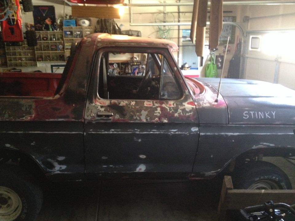 1978 Ford Bronco with rust and primer patches, side view. "STINKY" written on fender