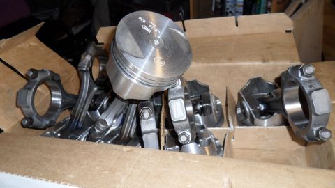 1972 Ford Ranchero - A collection of engine components, including pistons and connecting rods, are neatly arranged in a cardboard box.