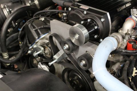 2003 Ford Crown Victoria - Close-up of a Kenne Bell supercharger mounted on an engine, showing the serpentine belt, pulleys and a blue coolant tube.