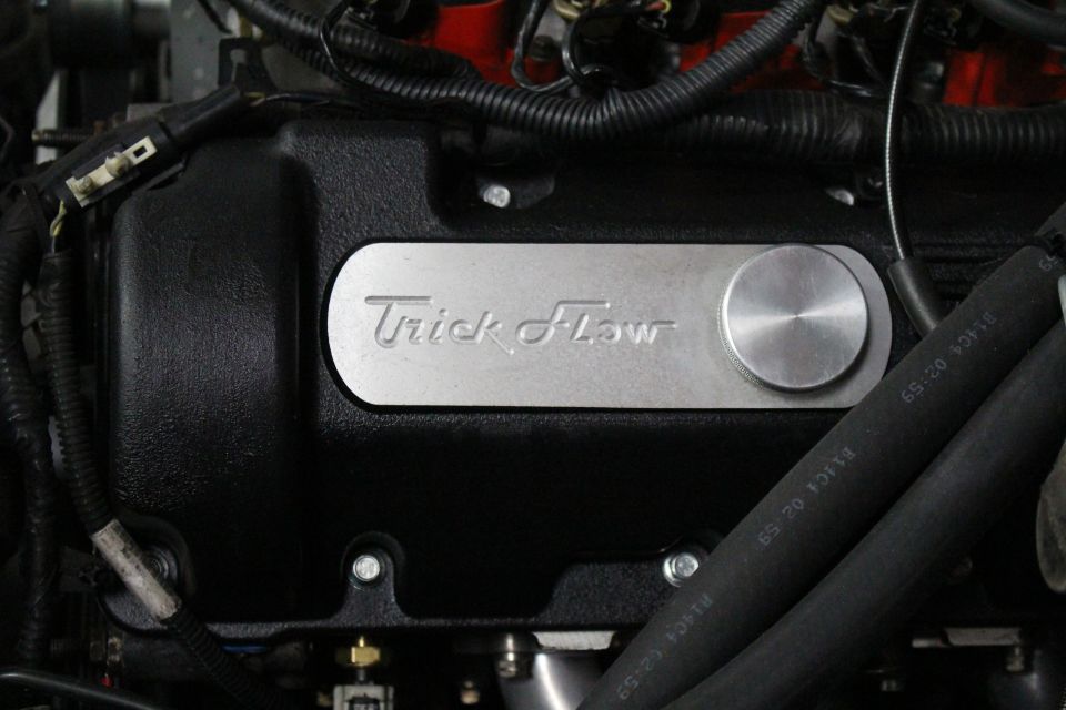 Close-up of a black Trick Flow engine valve cover with oil cap