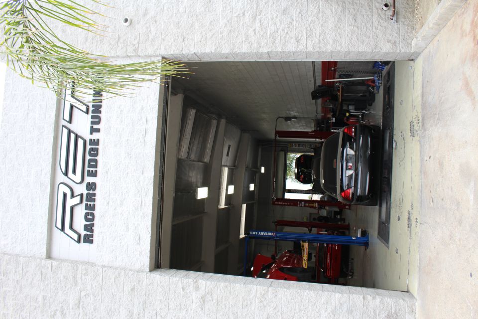 Shop entrance with Racers Edge Tuning sign and black sedan inside