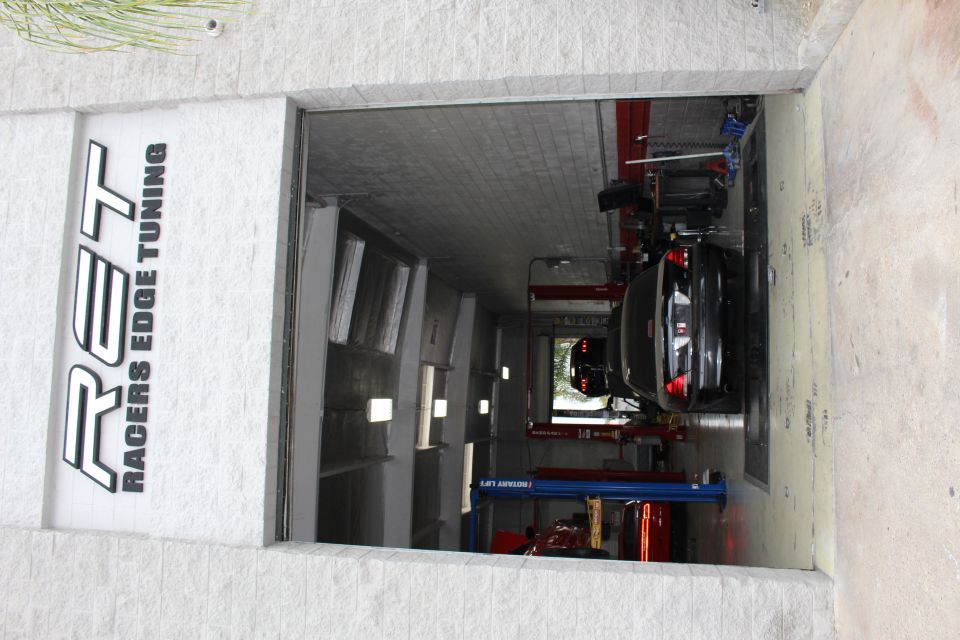 Racers Edge Tuning shop doorway with black sedan on dyno