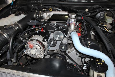 2003 Ford Crown Victoria - Engine compartment showing a Kenne Bell supercharger, chrome alternator, idler pulleys and a blue coolant hose.