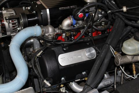 2003 Ford Crown Victoria - Close-up of a Kenne Bell supercharger above a black Trick Flow valve cover with blue coolant hose and braided lines.