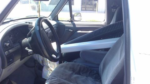 1994 Ford Bronco - Interior view of a 1994 Ford Bronco, with a large hose and pipe loaded inside.