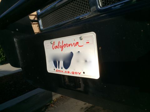 1997 Dodge 3500 - Close-up of a vehicle's front bumper, showing a California license plate with obscured characters.
