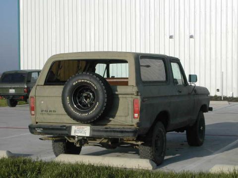 1978 Ford Bronco - Rear view of a 1978 Ford Bronco, showing its spare tire and license plate, with another vehicle nearby.