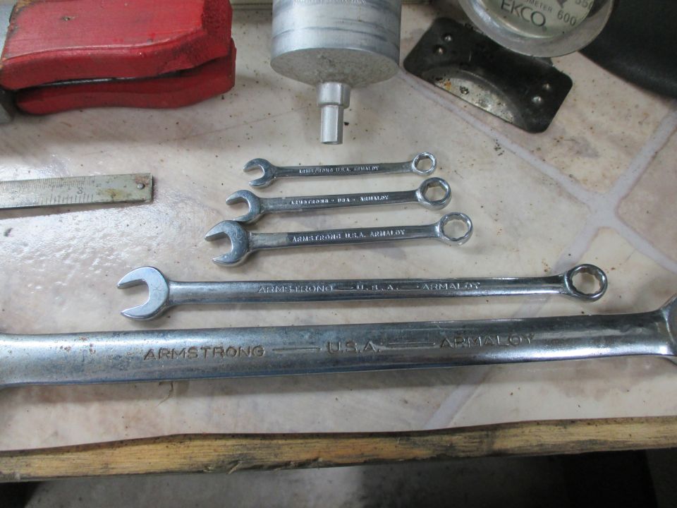 Several Armstrong USA Armaloy wrenches and other tools laid out on a surface