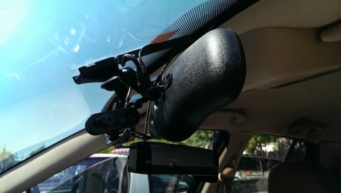 2000 Mercury Grand Marquis - The interior of a vehicle shows a dashcam and rearview mirror assembly attached to the windshield.