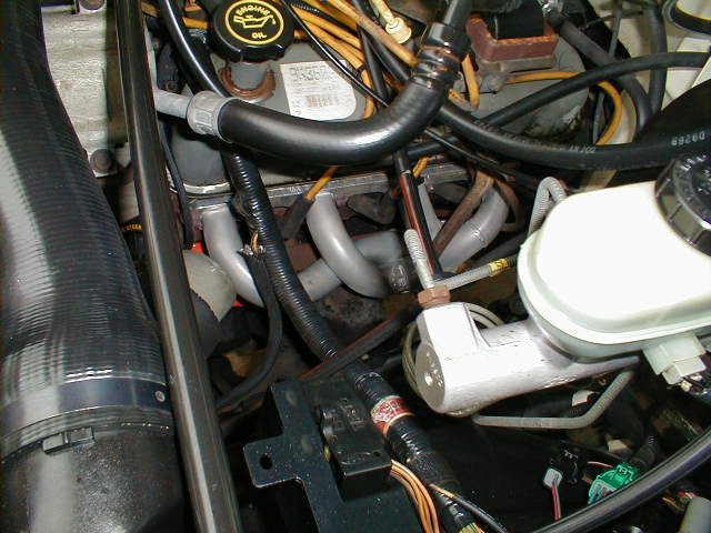 Engine bay closeup with white brake master cylinder, hoses, and oil filler cap marked ENGINE OIL