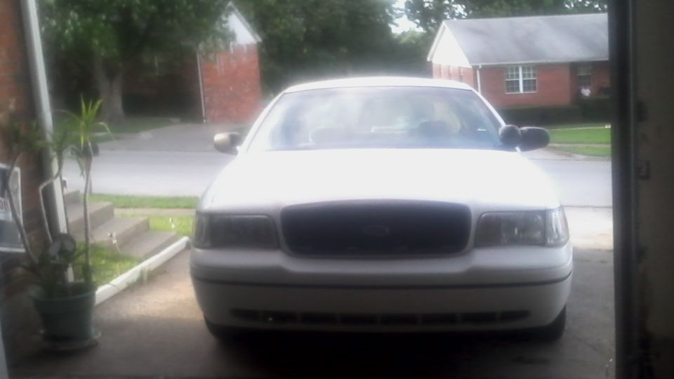 Front view of a white 2000 Ford Crown Victoria parked in a driveway