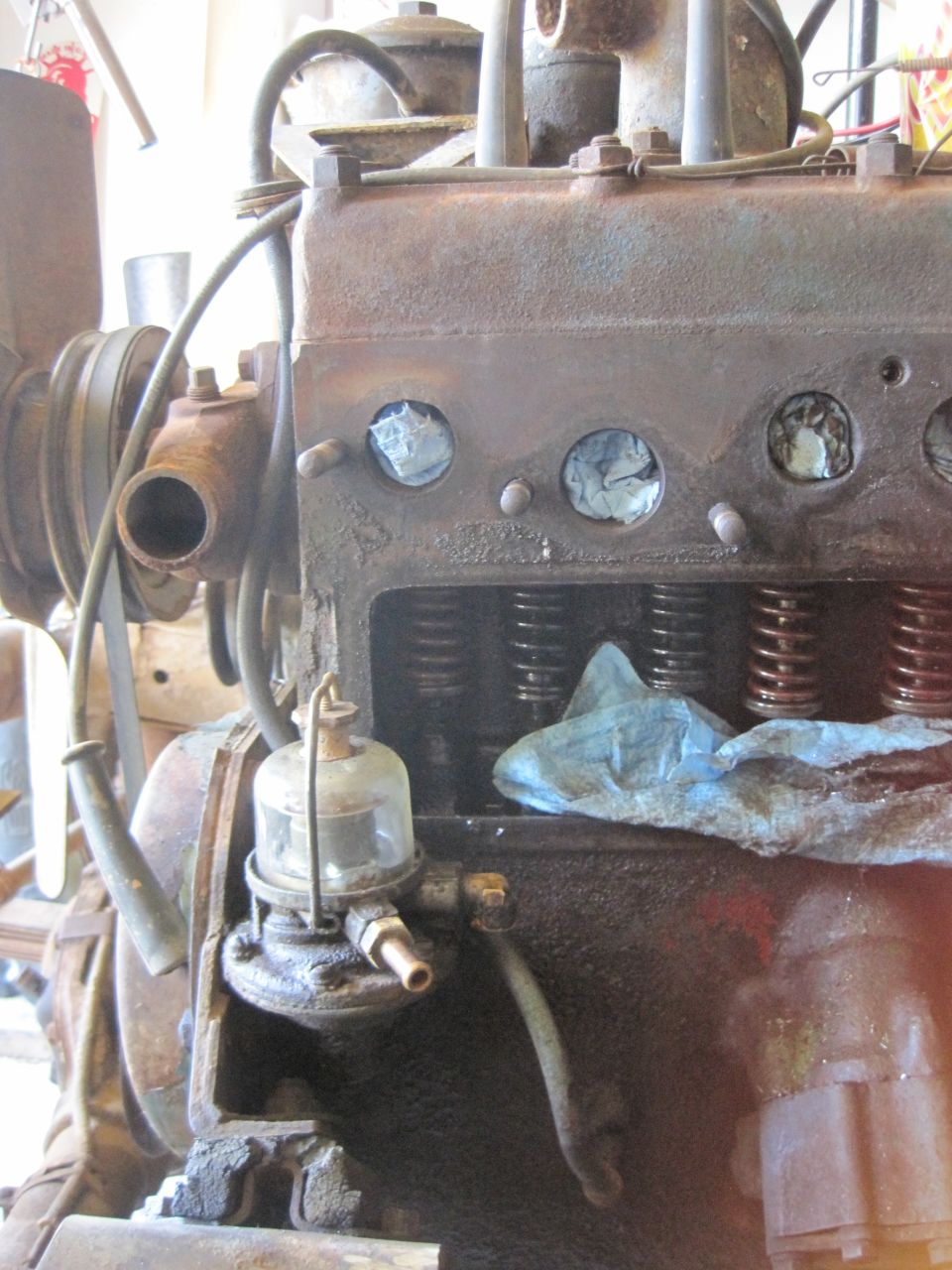 Rusty engine block with visible valves and a glass fuel filter