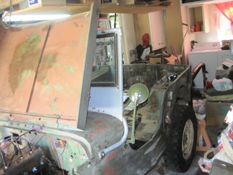 1946 Jeep Willys - This Jeep body is in a state of disrepair, with its hood open and interior exposed, suggesting it is undergoing restoration or is being sto…