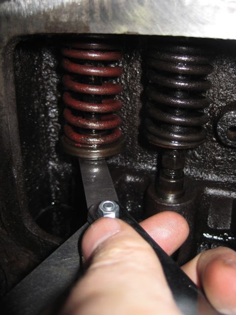 1946 Jeep Willys - Close-up of a mechanic adjusting an engine valve with a feeler gauge.