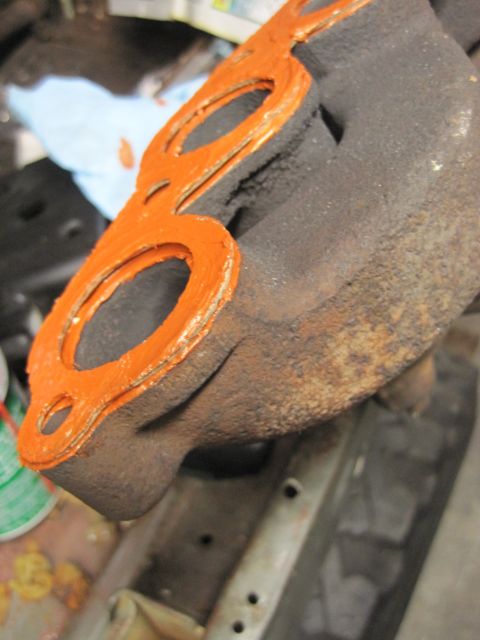 1946 Jeep Willys - Close-up of an exhaust manifold gasket with orange sealant applied, ready for installation.