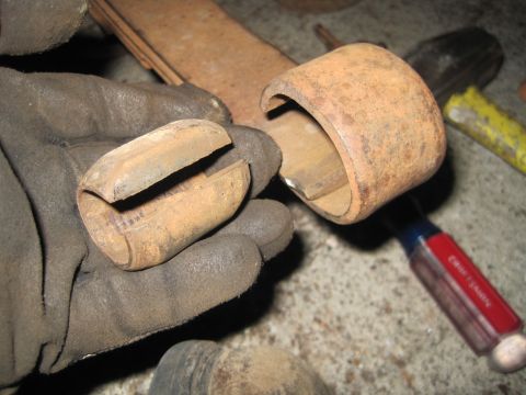 1946 Jeep Willys - Rusty leaf spring bushing and shackle parts are held by gloved hands.